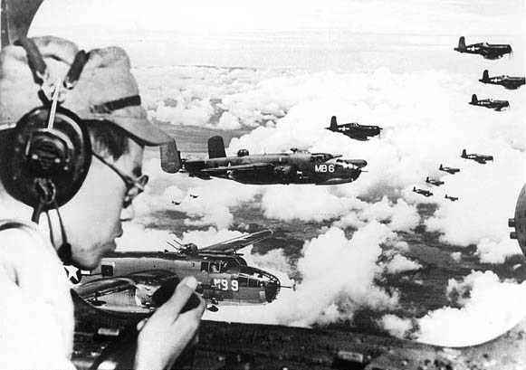 Japanese POW 2Lt Minoru Wada using the intercom aboard a USMC PBJ Mitchell bomber to relay instructions to his interpreter about the location of the Japanese 100th Infantry Division headquarters, Aug 9, 1945