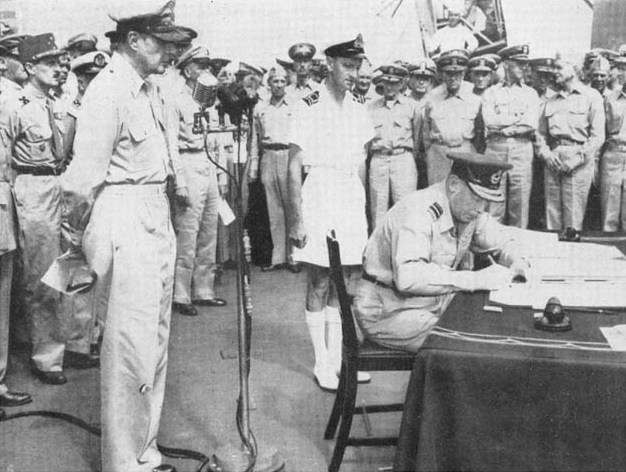 Air Vice-Marshal L.M. Isitt signing the surrender instrument on behalf of the Dominion of New Zealand aboard USS Missouri, Tokyo Bay, Japan, 2 Sep 1945