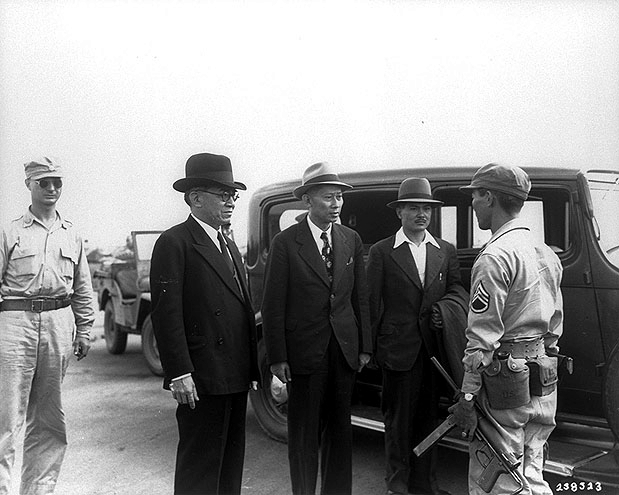 José Laurel being questioned by US Army non-commissioned officer of Filipino ethnicity Staff Sergeant Van Millori at No. 2 Osaka Airport, Osaka, Japan, 15 Sep 1945