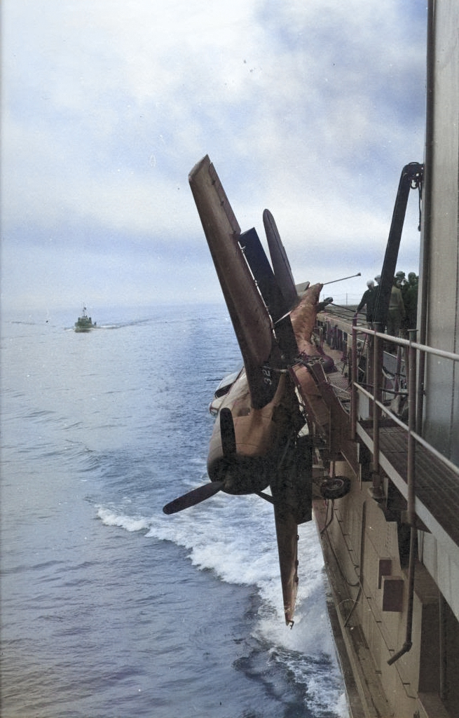 After an attempted landing on the training aircraft carrier USS Sable, an F6F Hellcat barely hangs onto the catwalks. Lake Michigan, United States, 1945. [Colorized by WW2DB]