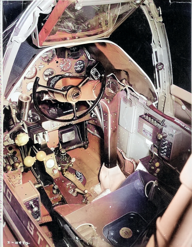 Close-up view of a P-38G Lightning aircraft cockpit, 23 Dec 1942; note the yoke rather than stick control and the bullet proof glass panel above the instrument panel. Photo 1 of 3. [Colorized by WW2DB]