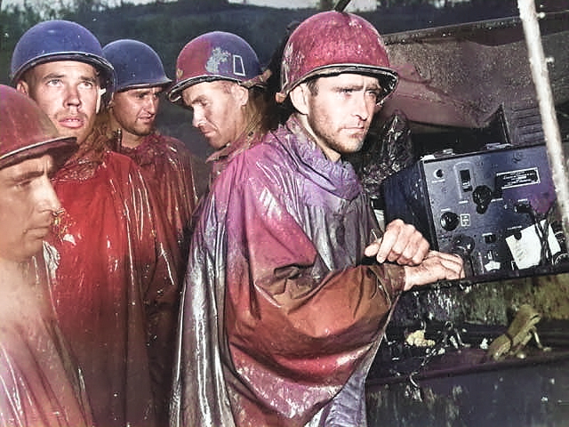 Men of the US Army 77th Infantry Division at Okinawa, Japan listening to radio reports for the German surrender, 8 May 1945 [Colorized by WW2DB]