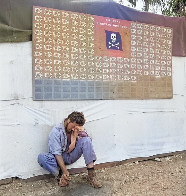 Tired member of US Navy VF-17 squadron paused under the squadron scoreboard at Bougainville, Solomon Islands, Feb 1944 [Colorized by WW2DB]