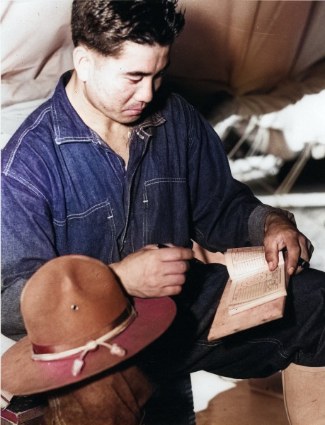 Japanese-American recruit reviewing his daily rifle score record, US Territory of Hawaii, date unknown [Colorized by WW2DB]