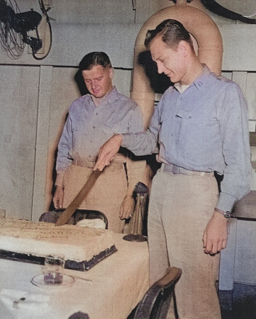 Lieutenant F. B. Underman (cutting cake) and Commander E. W. Davis celebrating the 5,000th landing aboard USS Anzio, 16 Apr 1945 [Colorized by WW2DB]