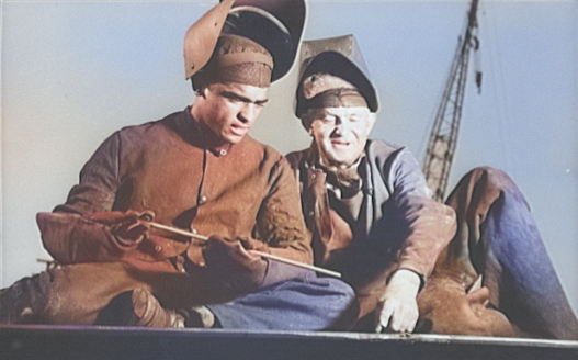 African-American welder Ernest Enloe Cotton learning from a more experienced colleague while building Liberty Ship Booker T. Washington, California Shipbuilding Corporation yard, Los Angeles, California, United States, Sep 1942 [Colorized by WW2DB]