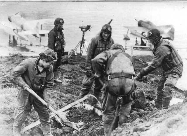 Japanese fighter pilots working at a plane anchorage on a Pacific island, 1940s; note two A6M2-N Type 2 Model 11 floatplanes in the background