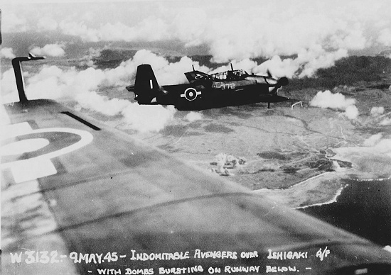 Royal Navy Avenger aircraft flying from HMS Indomitable in flight over Ishigaki Airfield, Ishigaki, Okinawa, Japan, 9 May 1945; note fire and explosions on the airfield