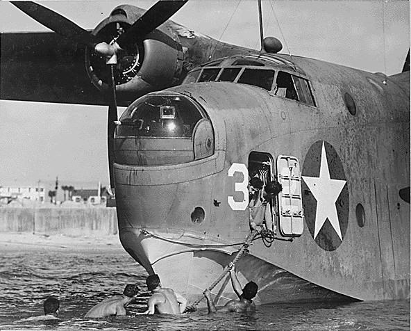 An US Navy beaching crew clinging to the tow line of a PBM Mariner aircraft, Naval Air Station Banana River, Florida, United States, circa Mar 1943