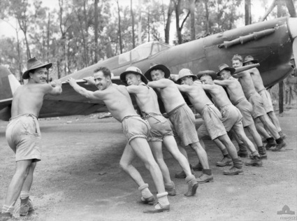 Australian crew of the No. 457 Squadron 'Grey Nurse' RAAF pushing a Spitfire fighter into its dispersal at Livingstone Airfield, Northern Territory, Australia, Feb 1943