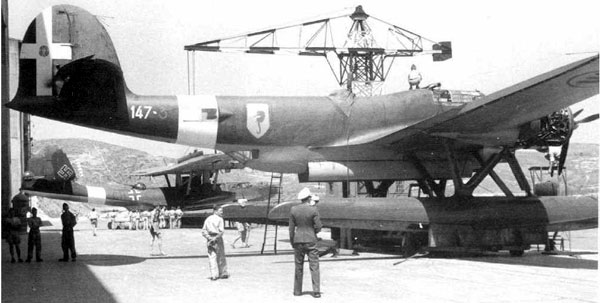 Z.506 Airone aircraft being transported on land, circa 1940s; note Do 24 float plane in background