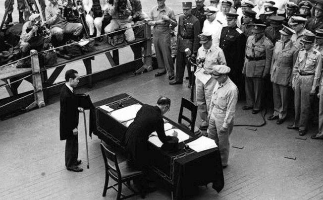 Mamoru Shigemitsu signing the surrender instrument aboard USS Missouri, Tokyo Bay, Japan, 2 Sep 1945, photo 2 of 4