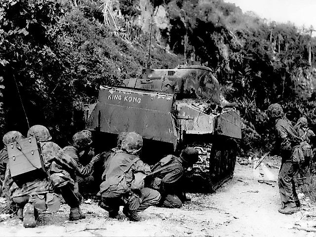 US Marines advancing under the cover of a M4 Sherman medium tank, northern Saipan, Mariana Islands, 8 Jul 1944