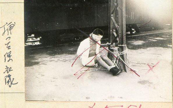 Chinese civilian bounded up at a train marshaling yard, Tianjin, China, Jul-Aug 1937; note Japanese censor's marks disallowing this photograph