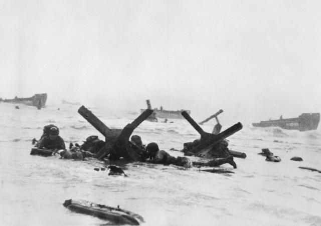 Soldiers of US 16th Infantry Regiment taking cover behind German beach obstacles, Normandy, France, 6 Jun 1944