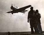 Landing Signal Officers stand-by as an SNJ Texan approaches training aircraft carrier USS Sable for a landing on Lake Michigan, United States, 1943.