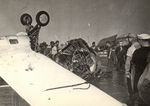 Crewmen detached the engine from an FM-2 Wildcat that had nosed all the way over on landing aboard training aircraft carrier USS Sable on Lake Michigan, United States, 1944.