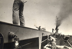 Crewmen hunker in the catwalks of training aircraft carrier USS Sable during flight operations on Lake Michigan, United States, 1944.