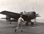 Deck crew signals the pilot of an FM-2 Wildcat aboard the training aircraft carrier USS Sable on Lake Michigan, United States, 1945.