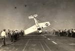 Deck crews aboard the training aircraft carrier USS Sable man lines to right an FM-2 Wildcat that had nosed completely over. Lake Michigan, United States, 1943-45. Photo 2 of 3.