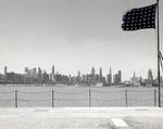 View of the Chicago, Illinois skyline from over the bow of the training aircraft carrier USS Sable anchored on Lake Michigan, United States, 1944-45.