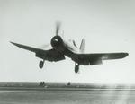 An F4U-1 Corsair with its gear down, flaps down, and hook down prepares to trap aboard the training aircraft carrier USS Wolverine on Lake Michigan, United States, 2 Apr 1943.