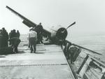 A Grumman F6F Hellcat with one wheel in the catwalks aboard the training aircraft carrier USS Wolverine on Lake Michigan, United States, 1945. Note the severely bent propeller blades.