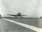 The absence of an extended tailhook as this SNJ-3 Texan passes over the arresting wires suggests a touch-and-go aboard the training aircraft carrier USS Wolverine on Lake Michigan, United States, 1943.