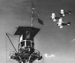 Grumman F3F “Flying Barrel” fighters fly by the mooring mast at Marine Corps Air Station Ewa, Oahu, Hawaii, mid-1941.