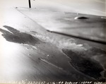 Strike photo taken from USS Intrepid aircraft showing burning targets and bomb splashes between the islands of Dublon and Fefan inside the Truk Lagoon (now Chuuk), Caroline Islands, 16 Feb 1944.