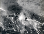 Damage control parties trying to bring fires under control on the flight deck of USS Intrepid following the crash of a Japanese special attack aircraft off the Philippines, 25 Nov 1944