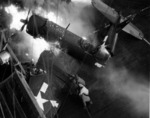 Marine F4U Corsair of VMF-123 aboard USS Bennington after crashing against the island, breaking in half, and catching fire, 14 Feb 1945 off Iwo Jima. Note burning fuel in the flight deck tie-down track.