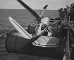 A TBF-1 Avenger of Torpedo Squadron VT-4 resting upside down on two of USS Ranger’s port stacks following a landing accident in the mid-Atlantic, 2 Mar 1943. Note the tailhook still hooked to the arresting cable.