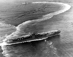 US carrier Ranger maneuvering with a destroyer escort in the central Atlantic, 27 Oct 1942. Note the stacks rotated to the horizontal for flight operations.