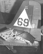 Damaged tail plane of an F6F-5 Hellcat of Fighting Squadron VF-20 on the hangar deck of USS Enterprise off the Philippines, 19 Oct 1944. Note the solid castor type tail wheel necessary for carrier operations.