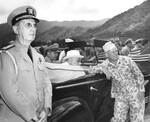 While touring Oahu, US Territory of Hawaii, President Franklin Roosevelt (seated in car) listened to Col William Saffarans (in jungle suit) at the Army’s Jungle Training Unit at Kahana Bay, 28 July 1944. Photo 1 of 2.