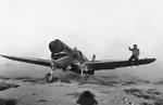 Kittyhawk Mark I fighter with the RAF 112 Squadron taxiing through the scrub of the Libyan desert, 2 Apr 1942. The crewman on the wing is helping guide the pilot whose view is obscured by the aircraft’s raised nose.