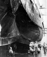 Crews inspecting midship torpedo damage to the heavy cruiser USS Chester in the Sutherland drydock at Cockatoo Island Dockyard, Sydney, Australia, Nov 1942.