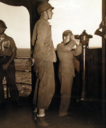 Japanese Navy pilot and US Navy sailor T. Treis aboard USS Cumberland Sound as the ship entered Tokyo Bay, Japan, 28 Aug 1945