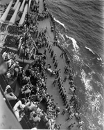 USS New Mexico transfering wounded from a destroyer off Saipan, just out of range of shore batteries, Jun 1944.