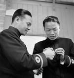 Chinese Navy Ensign Jang Jing-Ying (left) and Ensign Chen Kah (right) receiving instructions at the Chatham Gunnery School, England, United Kingdom, Aug 1945