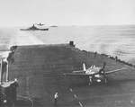 F6F-3 Hellcats of Fighting Squadron 16 (VF-16) landing aboard the USS Lexington (Essex-class), north of Manus, 28 Apr 1944. Note battleship USS South Dakota crossing Lexington’s wake.