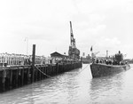 The submarine USS Argonaut approaching the pier at the submarine base in Pearl Harbor, Hawaii, 26 Aug 1942.