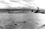 The overturned USS Utah, sunk by torpedoes in the Japanese air attack on Pearl Harbor, Hawaii, 7 Dec 1941. Cruiser USS Raleigh can be seen at right.