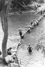 Members of US 5332nd Brigade (Provisional) building a temporary river crossing, west of Lashio, Burma, 1945, photo 1 of 2