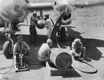 Members of the 894th Chemical Company mixing napalm and pumping it into a tank slung under the wing of a P-38J Lightning of the 8th Fighter Group at Elmore Airfield, Mindoro, Philippines, Apr 1945.