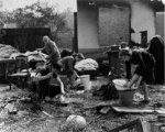 Polish family doing chores outside their destroyed home, Warsaw, Poland, Sep 1939