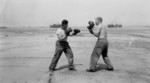 US Navy personnel (probably of USS LCT-535) posing with boxing gloves on a beach in Normandie, France, 1944