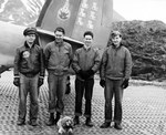 Ground Crewmen with Bombing Squadron 139 posing with their squadron mascot in front of the tail section of a PV-1 Ventura patrol bomber on Attu Island, Alaska, 4 Jun 1944. Note the Marsden mat surface.