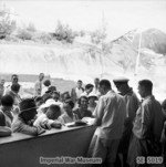 Recently freed internees of Stanley Internment Camp receiving tickets for their trip to Europe, Hong Kong, 18 Sep 1945